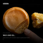 Ossion Beard Balm: the amber balm and a piece of beeswax on black