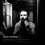 A man working Ossion Beard Serum through his beard in the morning