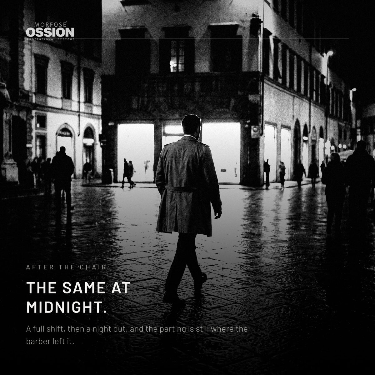 A man crossing a wet city plaza at night, his parting still sharp