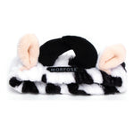 Morfose Milk Therapy spa headband on white — plush cow-print band with black horns and peach ears