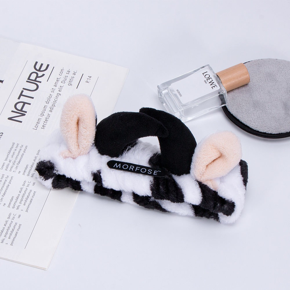 Morfose spa headband on a vanity with perfume and a reusable makeup remover pad