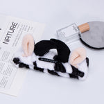 Morfose spa headband on a vanity with perfume and a reusable makeup remover pad