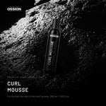 Ossion Curl Mousse can on wet black stone, lit from one side