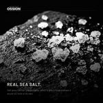 Coarse sea salt crystals on wet dark stone
